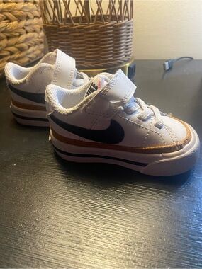 Nike Toddlers' White Sneakers with Black Swoosh and Gold Stripe
